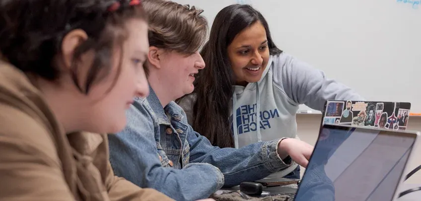 Three students working on laptops